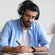 un homme avec un casque audio qui écrit