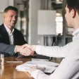Un candidat qui sert la main à un recruteur Un candidat qui sert la main à un recruteur