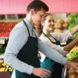 un homme qui travaille dans un rayon de légumes dans un supermarché