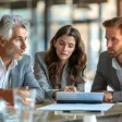 Collaborateurs échangeant de manière informelle autour d'un café, renforçant la cohésion d'équipe et la communication au travail.