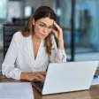 Employé la tête dans les mains devant son ordinateur, illustrant la fatigue extrême du burn-out.