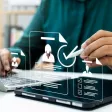 Responsable RH examinant un tableau de bord de recrutement et des CV pour détecter les pièges à éviter.