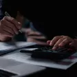 Responsable RH rédigeant une note de service sur les congés payés, affichée sur un écran partagé.