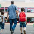 Un père dépose ses deux enfants à l'école le jour de la rentrée