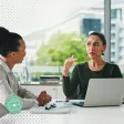 Une manageuse échange avec sa collaborateur autour d'un bureau