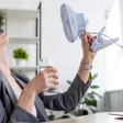 Femme qui se ventile durant la canicule au bureau 
