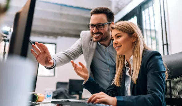 équipe souriante devant ordinateur