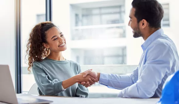 femme souriante serrant la main à son collège