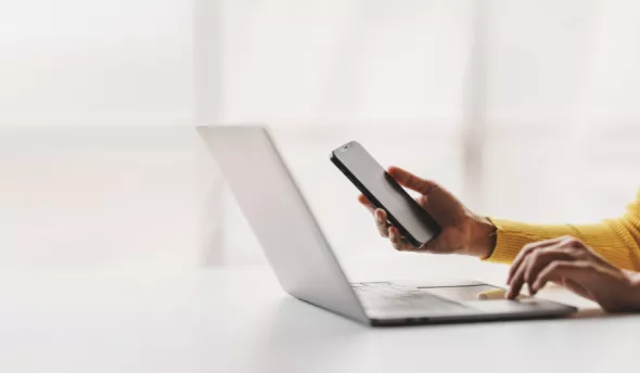 femme devant ordinateur et téléphone
