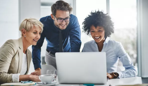 collaborateurs souriants devant ordinateur