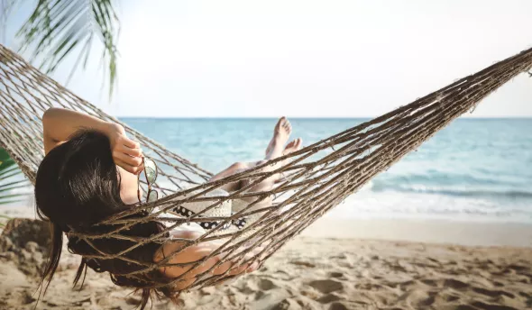 Femme dans un hamac en vacances à la plage