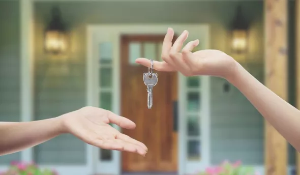 Une personne qui donne une paire de clés pour un logement à une autre personne