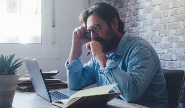 Homme qui travaille seul devant son ordinateur, méthode de travail en silo