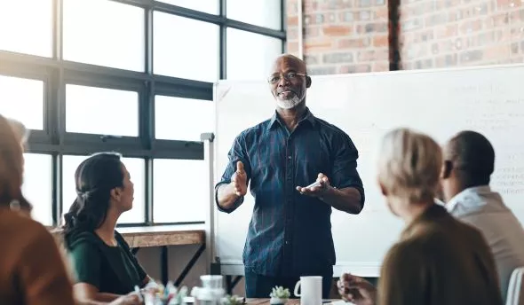 Senior homme d'affaires présentant lors d'une réunion