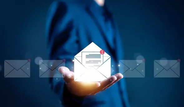 Professionnel en train de concevoir une newsletter d'entreprise, avec des éléments clés comme le design, le contenu engageant et l'analyse des performances.