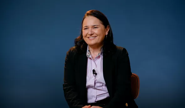 l'intervenante est assise sur un fauteuil et sourit