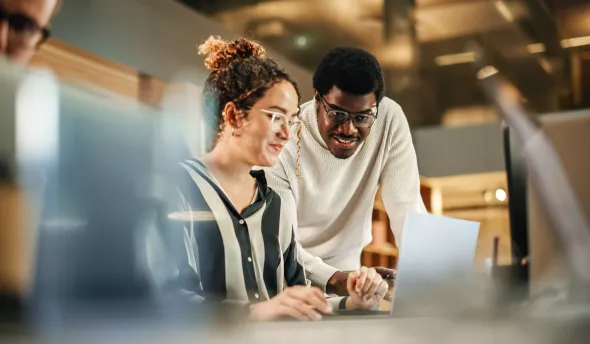 Un manager explique quelque chose à sa collègue alternante