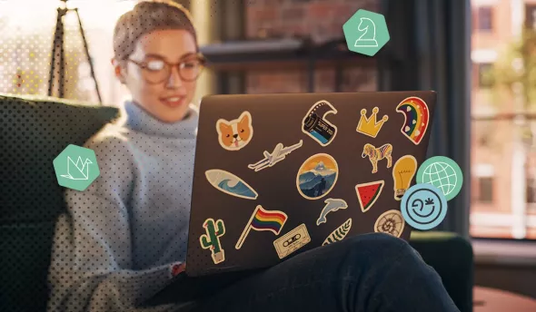 Une femme travaillant sur un ordinateur portable décoré d'autocollants colorés