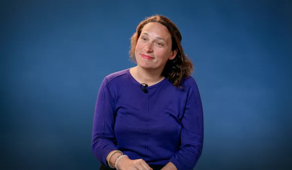 l'intervenante est assise sur un fauteuil et sourit