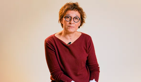 L'intervenante est assise sur une chaise en regardant la caméra