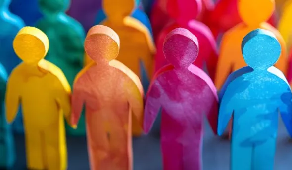 Équipe enthousiaste réunie autour d’un panneau affichant les valeurs de l’entreprise, incarnant le sentiment d’appartenance.