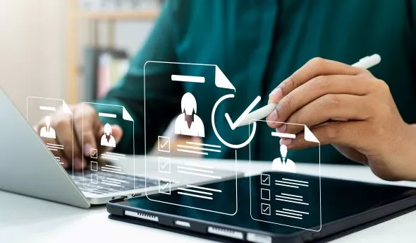 Responsable RH examinant un tableau de bord de recrutement et des CV pour détecter les pièges à éviter.