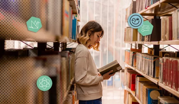Femme lisant un livre dans une bibliothèque, concentrée sur la lecture et l’apprentissage