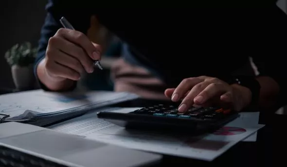 Responsable RH rédigeant une note de service sur les congés payés, affichée sur un écran partagé.