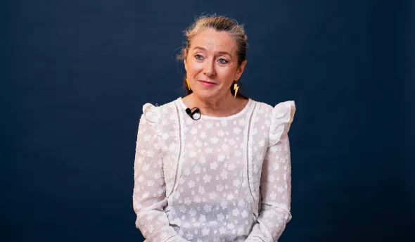 l'intervenante est assise sur un fauteuil et sourit