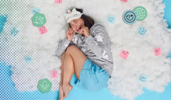 Une femme est entourée de post-it allongée sur un lit