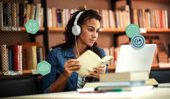 Jeune femme étudiant avec un livre et un ordinateur portable dans une bibliothèque moderne.