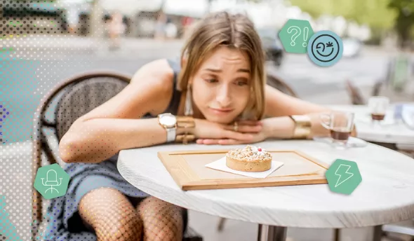 Une parisienne songeuse a une terrasse d’un café regardant une petite tarte posée sur la table