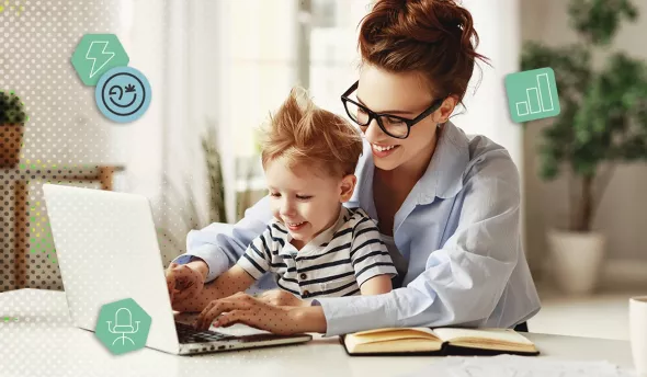 Mère souriante en télétravail avec son enfant sur les genoux, devant un ordinateur portable