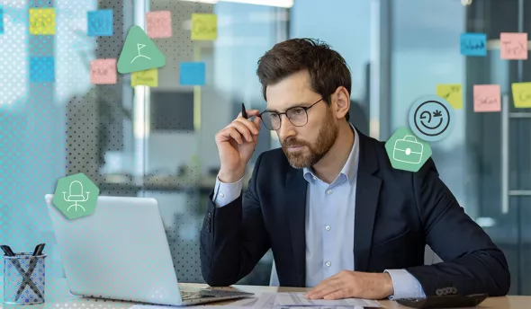 Homme concentré en costume travaillant sur ordinateur dans un bureau moderne
