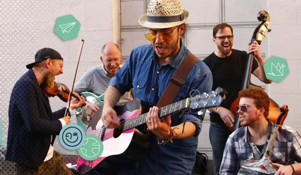 Groupe de musiciens de rue jouant de la guitare, violon et contrebasse avec énergie.