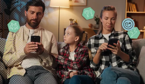 Un enfant observe son parent absorbé par l’écran de son smartphone.