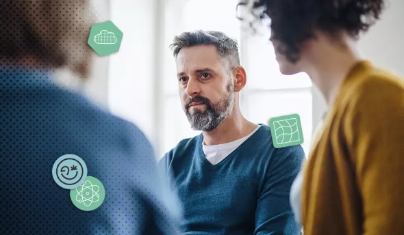 Homme pensif en réunion entouré de collègues flous dans un bureau