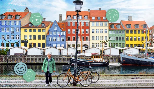 Femme senior marchant le long du canal de Nyhavn à Copenhague, maisons colorées et vélos en arrière-plan