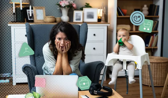 Mère stressée travaillant à domicile avec son bébé assis à côté dans une chaise haute
