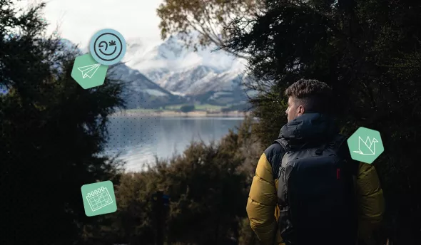 Personne en backpack (sac à dos) dans la forêt contemplant les montagnes enneigées et le lac Hawea, île du Sud de la Nouvelle-Zélande