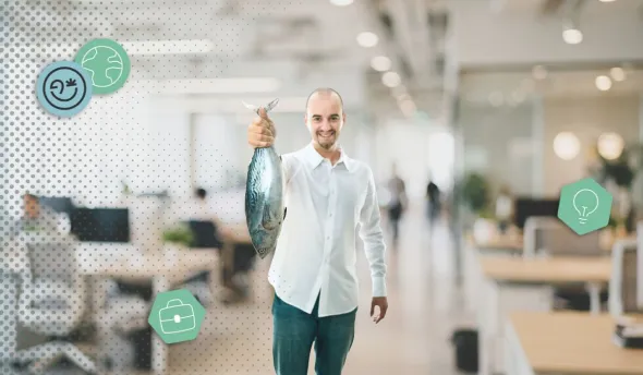 Un homme tient un poisson dans un openspace