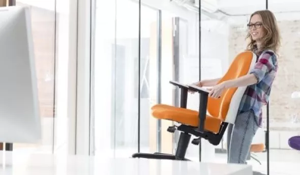Femme qui change de chaise de bureau durant la semaine de la QVT
