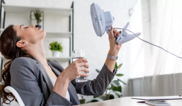 Femme qui se ventile durant la canicule au bureau 