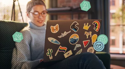 Une femme travaillant sur un ordinateur portable décoré d'autocollants colorés