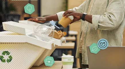 Personne triant déchets dans une borne de collecte, insérant gobelet carton et bouteille plastique