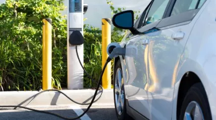 Conducteur rechargeant sa voiture électrique avant un déplacement professionnel.