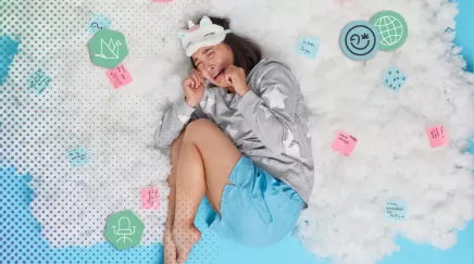 Une femme est entourée de post-it allongée sur un lit