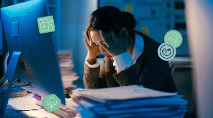 Salariée en détresse face à une pile de dossiers, assise devant un écran