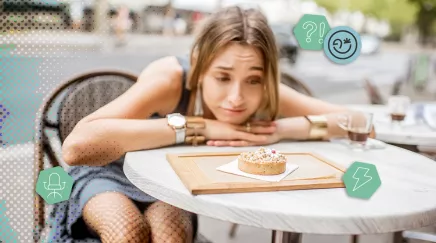 Une parisienne songeuse a une terrasse d’un café regardant une petite tarte posée sur la table