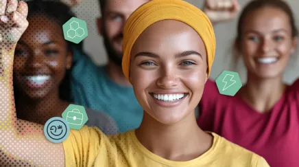 Quatre jeunes collègues, trois femmes et un homme, levant le poing en signe de solidarité et d’égalité au travail